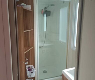 Salle d'eau avec cabine de douche et lavabo dans le MOBIL HOME LMNP GUIGON