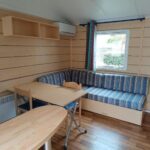 Séjour avec banquette rayée et table dans le mobil home Lucky climatisé du camping Port la Nouvelle