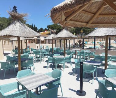 Terrasse au bord de la piscine avec parasols et tables au Mobil home Front de Mer Carry le Rouet