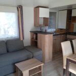 Salon et kitchenette lumineux dans le Mobil-home Tout Confort trois chambres du Domaine de Kerlann