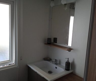 Salle de bain avec lavabo et miroir dans le mobil-home tout confort du Domaine de Kerlann