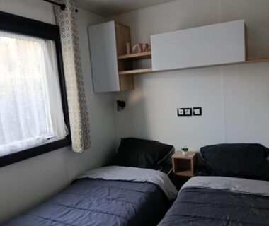 Chambre avec deux lits simples et fenêtre du mobil home tout confort Camping LA RESERVE