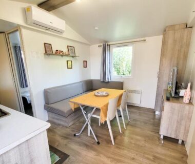 Séjour avec coin repas banquette et climatisation dans le mobil-home d'Anne et Edouard