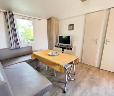 Intérieur avec canapé table et télévision du mobil-home d'Anne et Edouard
