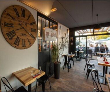 Intérieur avec tables et grande horloge murale, terrasse extérieure visible du MOBIL HOME n 1 TOUT CONFORT ST CYPRIEN 66