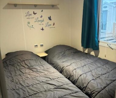 Chambre avec deux lits simples et fenêtre dans le MOBILE HOME Clim-Piscine -Terrasse -Parking -6 personnes