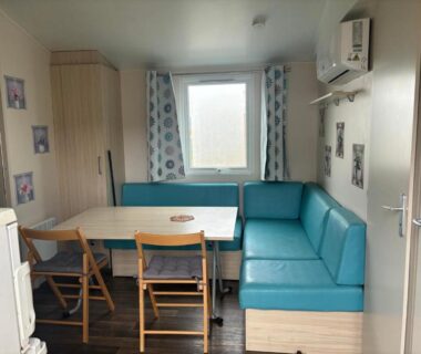 Intérieur coin repas avec banquette et climatisation dans le mobile home Clim Piscine Terrasse Parking 6 personnes