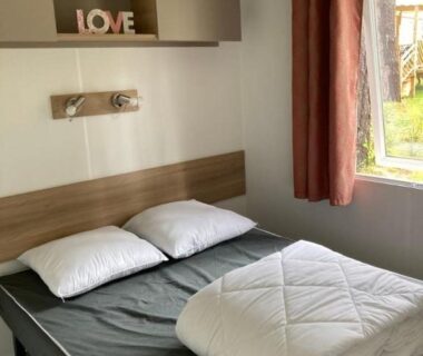 Chambre avec lit et fenêtre du mobilhome 4 à 6 personnes terrasse couverte