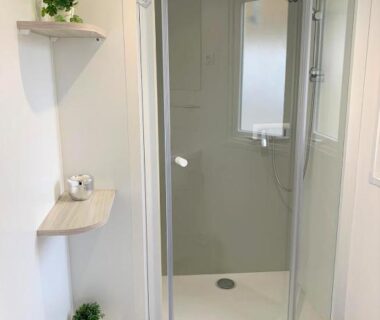Salle de bains avec douche cabine et étagères dans le MOBILHOME 3 CH CAMPING 4*