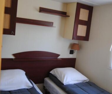 Chambre avec deux lits simples et étagères dans le mobilhome 3 chambres