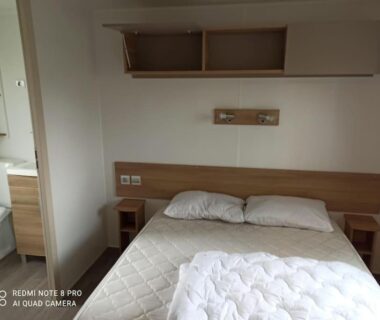 Chambre avec lit double et rangements dans MOBILHOME 3 CHBRES 2 SDE 2 WC LV LL TV CLIM TOUT CONFORT