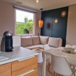 Salon avec canapé et coin cuisine dans le MOBILHOME 6p 3 CH 2 SDB SAINT JEAN DE MONTS