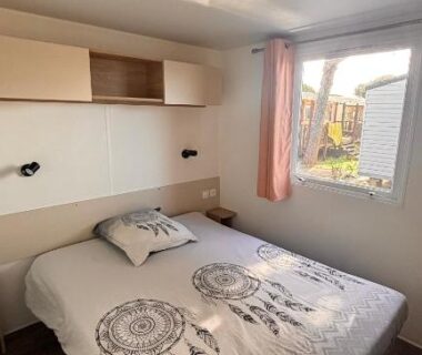 Chambre intérieure avec lit double et fenêtre dans le Mobilhome BORA BORA 6 à 8 personnes