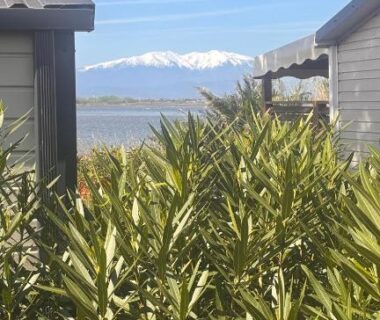 Vue sur la mer et les Pyrénées entre deux mobil-homes au MOBILHOME BORA BORA 6 à 8 PERSONNES