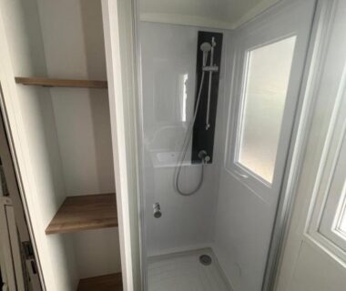 Douche vitrée avec fenêtre et étagères dans le mobilhome Narbonne Plage