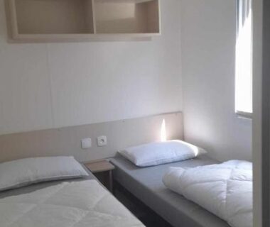 Chambre avec deux lits simples et rangement dans le mobilhome en bord de mer sur camping 4 étoiles