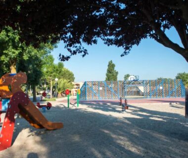 Aire de jeux ombragée avec toboggan et sol sablé au Mobilhome Fabuleux Camping Vias Plage