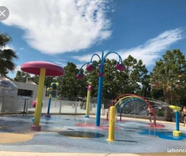 Pataugeoire et jeux d'eau colorés dans l'aire aquatique au Mobilhome Fabuleux Camping Vias Plage
