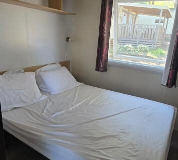 Chambre avec lit et fenêtre du Mobilhome Lodge 3 chambres