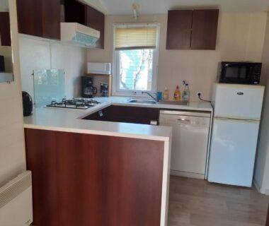 Cuisine équipée avec plaque cuisson micro-ondes et réfrigérateur dans le mobilhome agréable sans draps ni serviettes