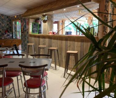 Bar intérieur avec comptoir et tabourets au camping MODULO VIP