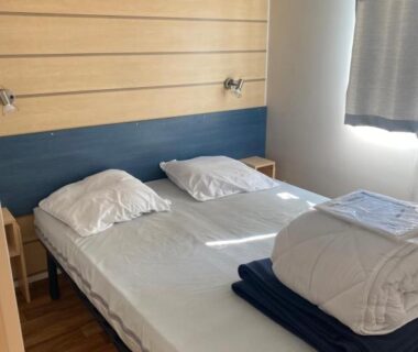 Chambre avec lit double et linge plié dans le mobile home MORREALE MOBILE HOME