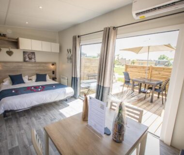 Séjour et terrasse avec lit et coin repas du M&V Resort Camping