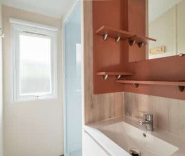 Salle de bains avec lavabo miroir et douche au Maïana Resort