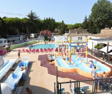Espace aquatique avec toboggans pataugeoire et transats au Maïana Resort