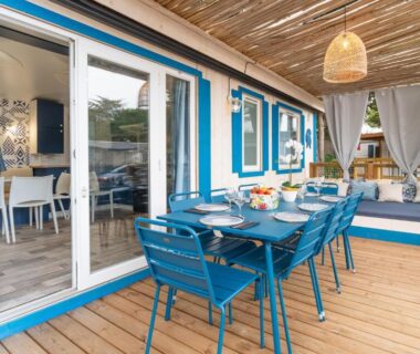 Terrasse en bois avec table et chaises sous pergola au Maïana Resort