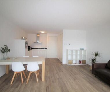 Salon avec coin repas et cuisine intégrée dans la MaisonBruyess M1
