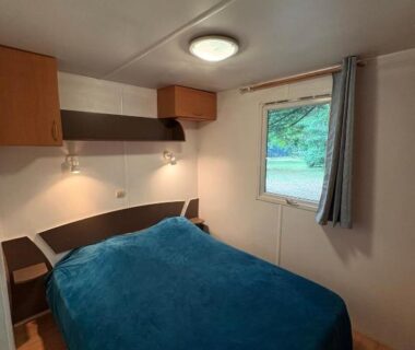 Chambre intérieure avec lit double et fenêtre dans le bungalow Manoir le Mingreaud