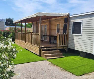 Terrasse en bois avec table et pelouse du mobil-home Mar Estang Siblu