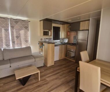 Intérieur de mobil-home avec coin cuisine et salon au Mar estang Siblu