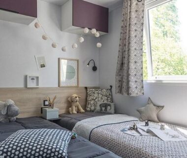 Chambre avec deux lits et guirlande lumineuse au Camping de l'Arquet