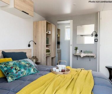 Intérieur de location avec lit et rangement au Camping de l'Arquet