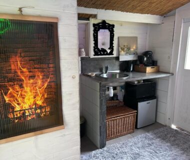 Intérieur avec kitchenette et cheminée du mini chalet cozy esprit zen et insolite
