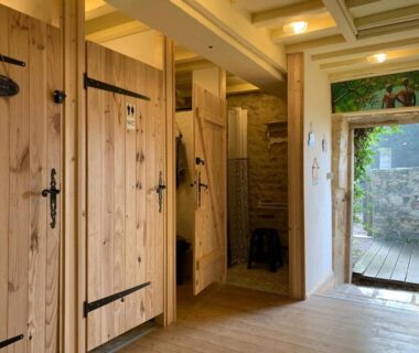 Couloir de sanitaires en bois dans le Minicamping Sous les Cloches