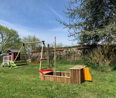 Aire de jeux avec balançoire et bac à sable au Minicamping Sous les Cloches