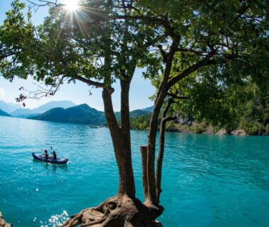 Rivage d'un lac avec barque et arbres au Minicamping Sous les Cloches