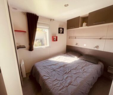 Chambre avec lit double et rangements dans le Mobi Home Palmiers 2