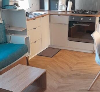 Cuisine équipée avec four micro-ondes et coin repas dans le Mobihome
