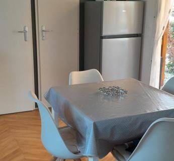 Séjour avec table chaises réfrigérateur et télévision dans le Mobihome