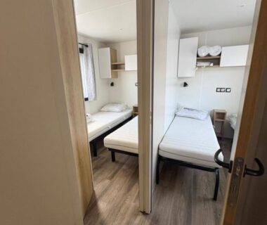 Intérieur avec deux lits simples séparés dans le Mobil Home