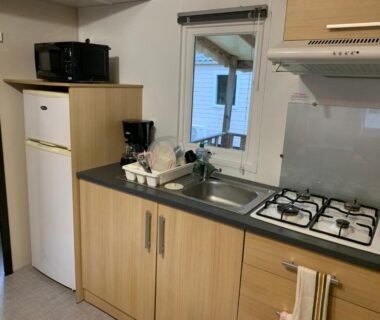 Intérieur kitchenette avec plaques gaz évier micro-ondes et réfrigérateur dans le Mobil-Home -10 minutes Océan