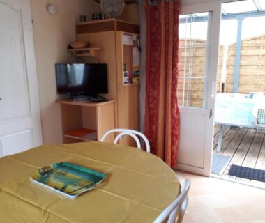 Coin repas et télévision près de la terrasse dans le Mobil Home 14