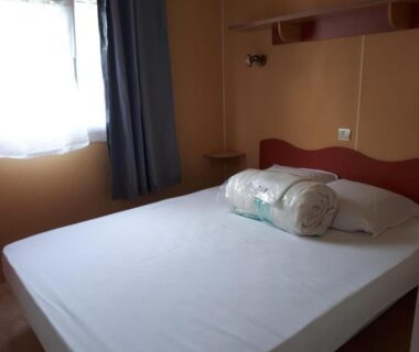 Intérieur chambre avec lit et fenêtre dans le Mobil Home 14
