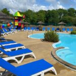Bord de piscine avec transats et aire de jeux au Mobil Home