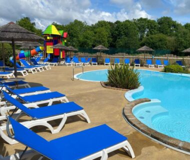 Bord de piscine avec transats et aire de jeux au Mobil Home