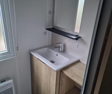 Salle d'eau avec lavabo et miroir dans le Mobil Home